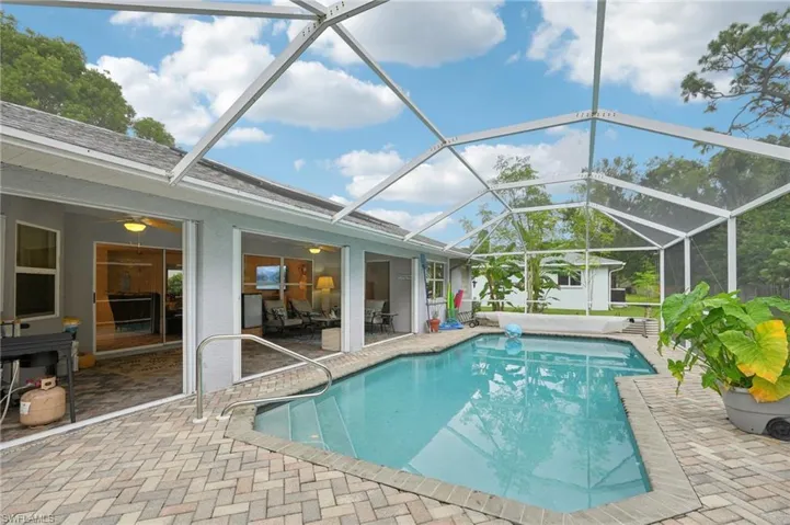 View of swimming pool with a patio and glass enclosure