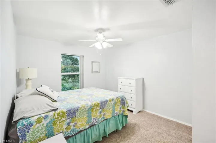 Carpeted bedroom featuring ceiling fan