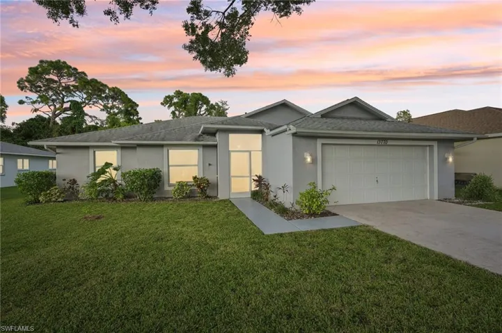 Single story home featuring a yard and a garage