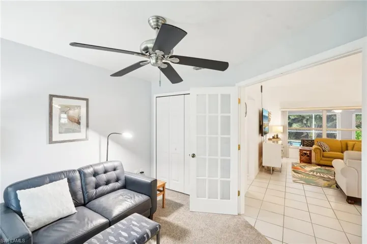 Living room with ceiling fan and light tile patterned floors