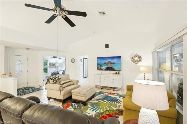 Tiled living room with high vaulted ceiling and ceiling fan