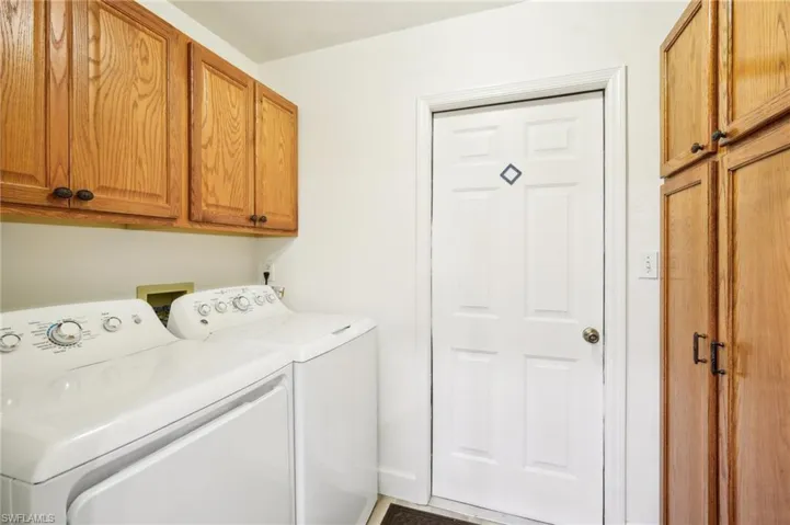 Laundry area featuring cabinets and washing machine and dryer