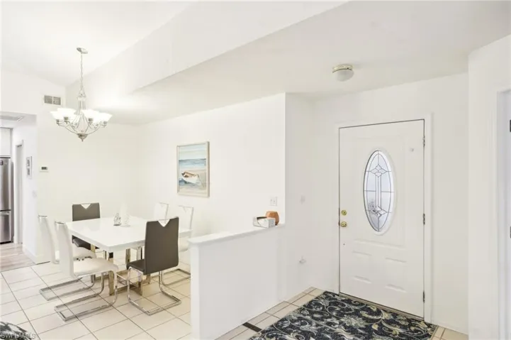 Tiled foyer entrance featuring an inviting chandelier