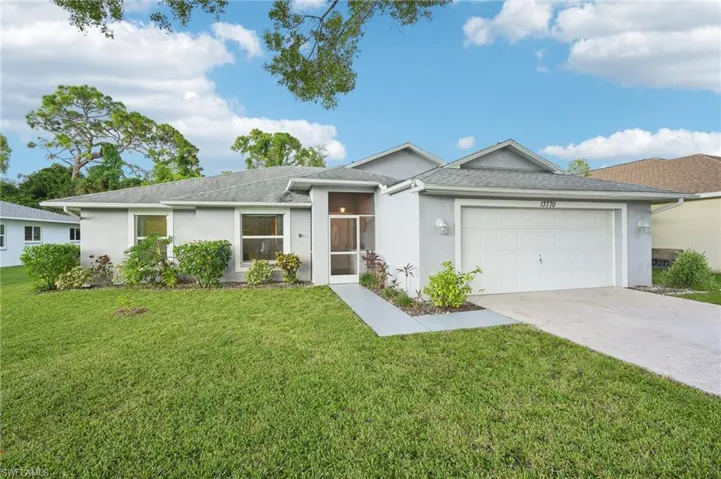 Single story home with a garage and a front lawn