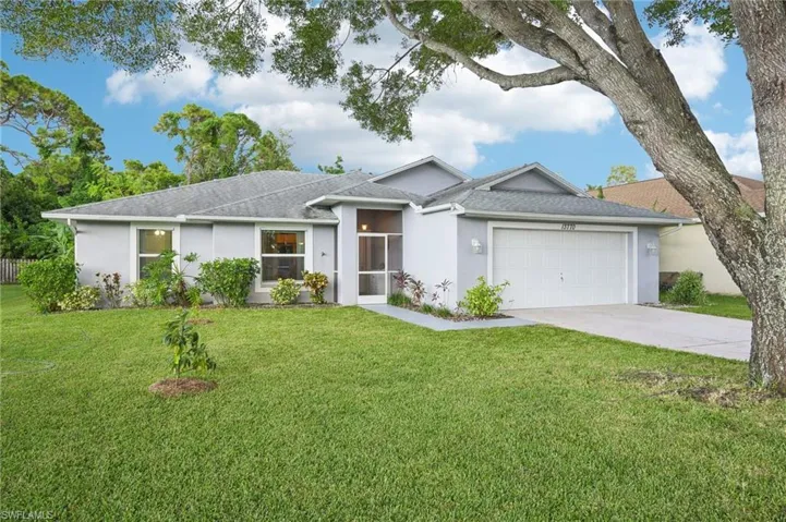 Single story home featuring a garage and a front lawn