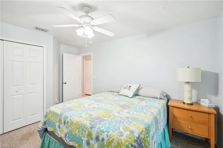 Bedroom featuring light carpet, a closet, and ceiling fan