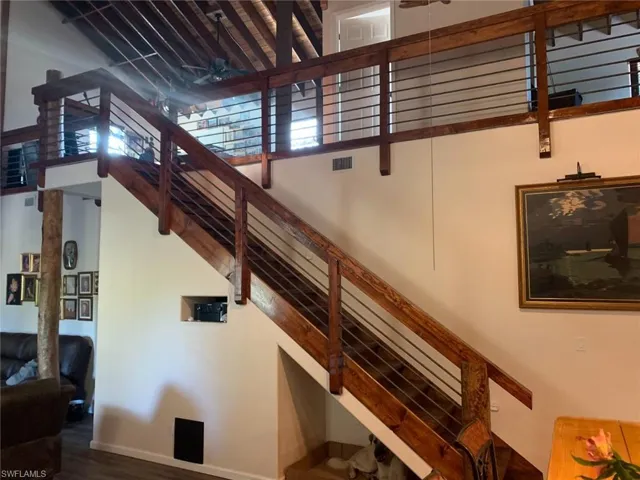 Stairway featuring a high ceiling, wood finished floors, and ceiling fan