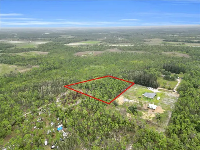 Aerial view of property's location featuring property boundaries highlighted and a forest