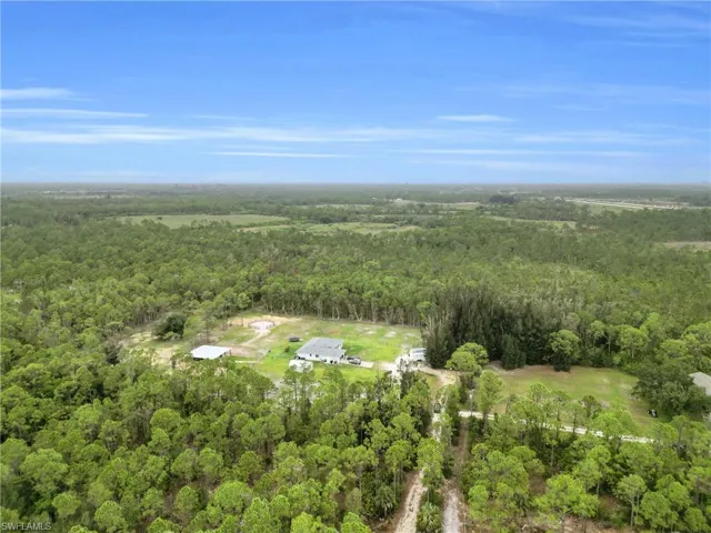 View of property location with a heavily wooded area