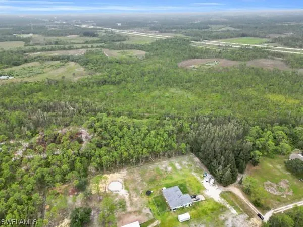 Aerial view of property's location with a heavily wooded area