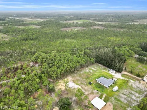 Aerial view of property and surrounding area featuring a heavily wooded area