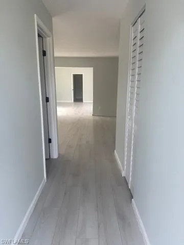 Hall featuring light wood-type flooring and baseboards