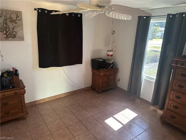 Tiled bedroom featuring ceiling fan