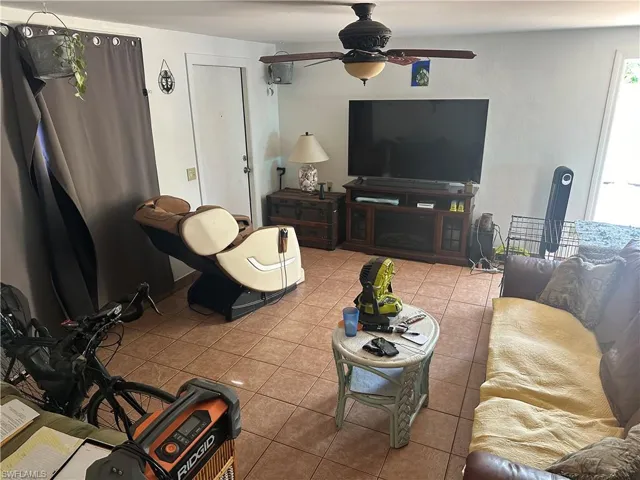 Tiled living room featuring ceiling fan