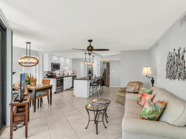 Living room with sink, ceiling fan with notable chandelier, and light tile patterned flooring