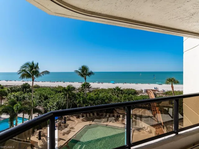Balcony featuring a water view and a beach view