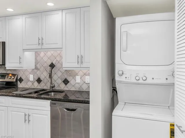 Laundry area featuring stacked washer and dryer and sink