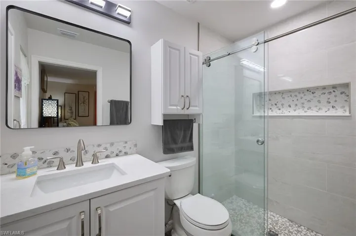 Full bath featuring a shower stall and vanity