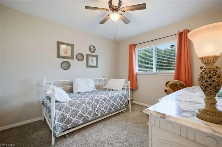 Carpeted bedroom featuring baseboards and a ceiling fan
