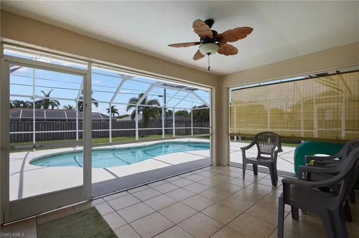 View of swimming pool featuring a patio area, a fenced backyard, ceiling fan, and a lanai