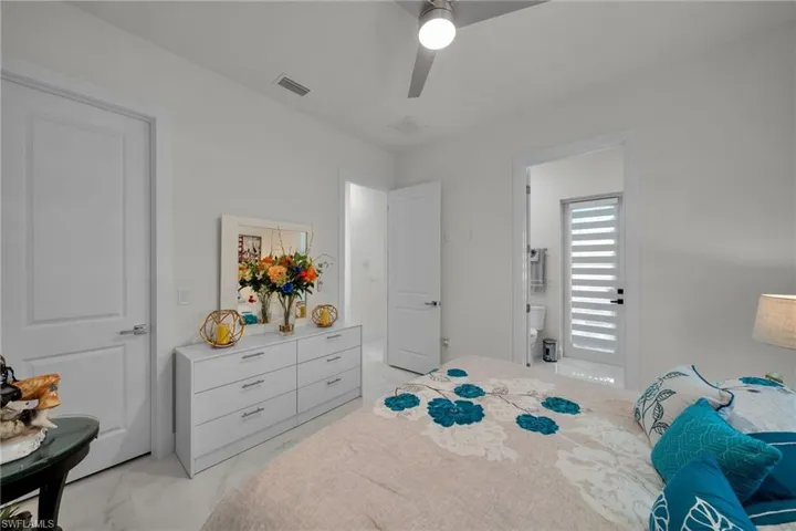 Bedroom featuring light marble finish floors and ceiling fan