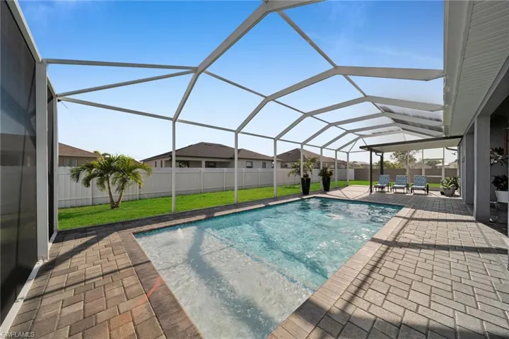 View of swimming pool with a sunroom, a patio, glass enclosure, and a fenced backyard