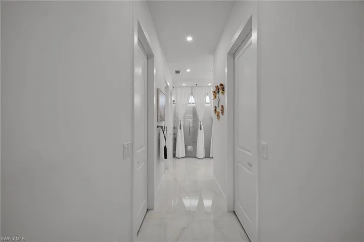 Hall featuring recessed lighting and light marble finish floors