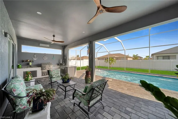 Fenced backyard featuring area for grilling, a sunroom, a patio, a ceiling fan, and a lanai