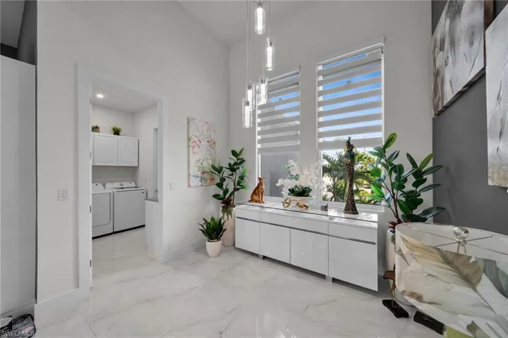 Bathroom featuring light marble finish floors, washer and dryer, and vanity