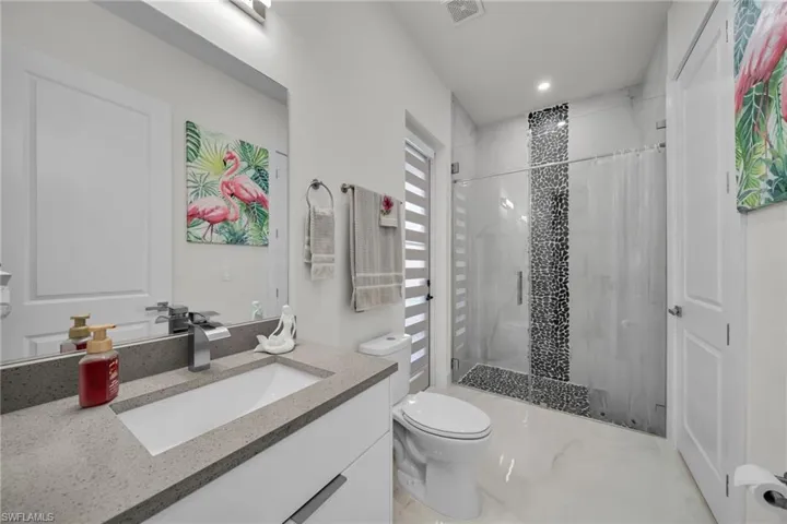 Full bathroom with a stall shower, vanity, and recessed lighting