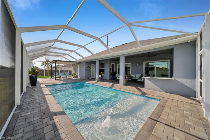 Swimming pool with a sunroom, a patio area, a lanai, and ceiling fan
