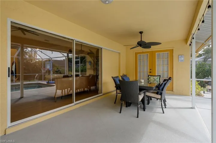 Sunroom featuring ceiling fan, outdoor dining area, and a patio