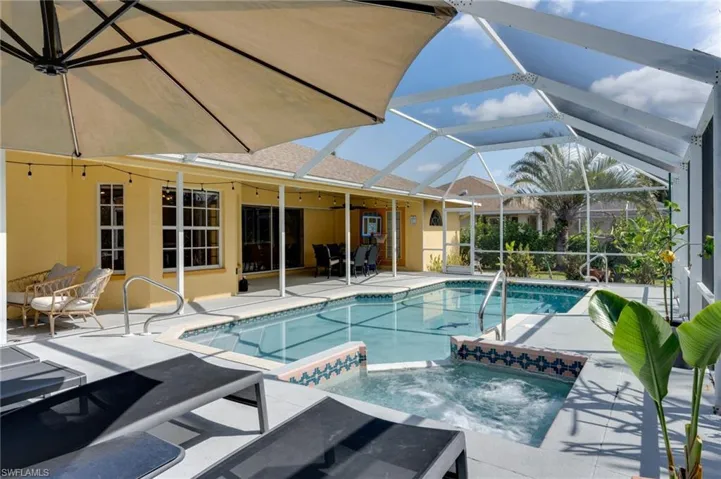 Combined pool / hot tub with a patio area, a sunroom, and a lanai