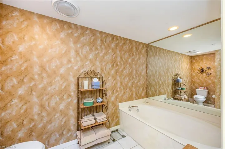 Bathroom featuring light tile patterned floors, a garden tub, and recessed lighting