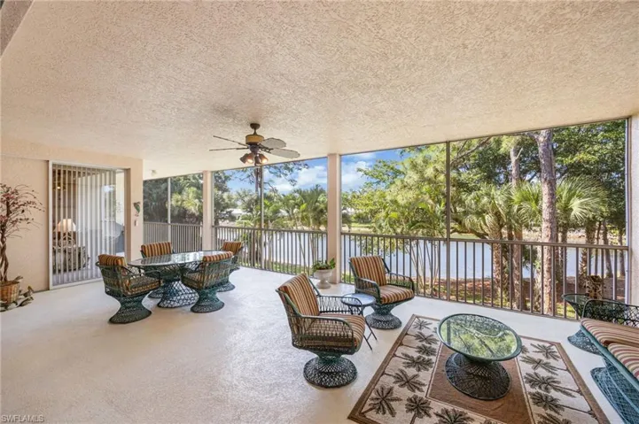Sunroom with a ceiling fan, outdoor lounge area, and a water view