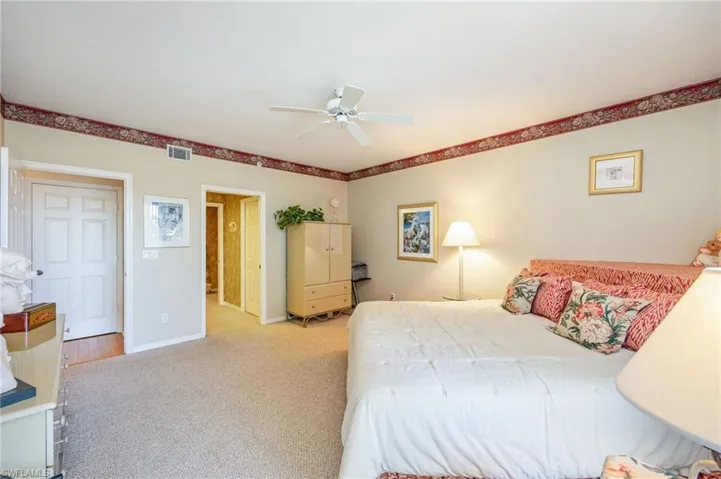 Carpeted bedroom with baseboards and a ceiling fan