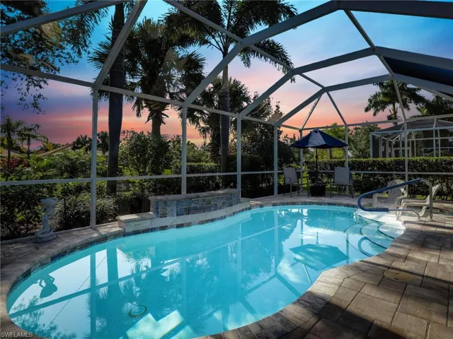 Pool at dusk with a patio area and a lanai