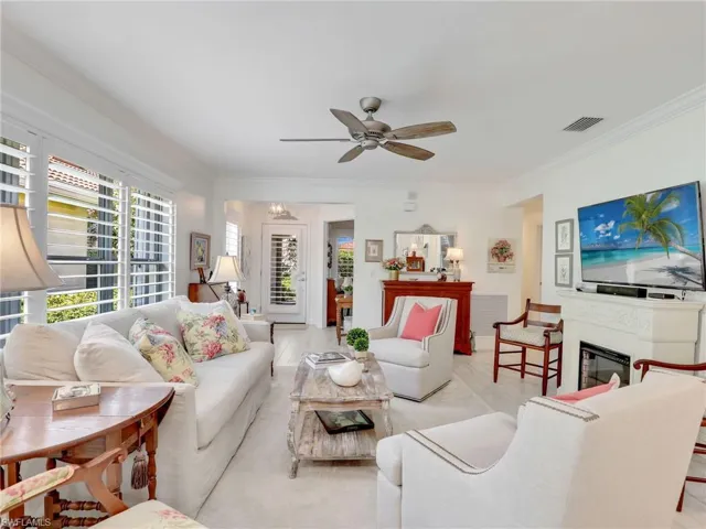 Living room featuring light hardwood / wood-style floors, ceiling fan, and crown molding