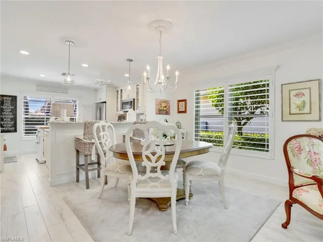 Dining area featuring ornamental molding, light hardwood / wood-style floors, and an inviting chandelier