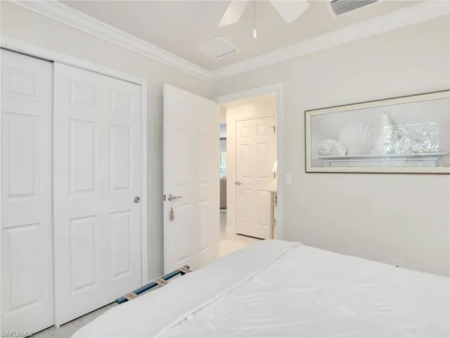 Bedroom with ceiling fan, a closet, and crown molding
