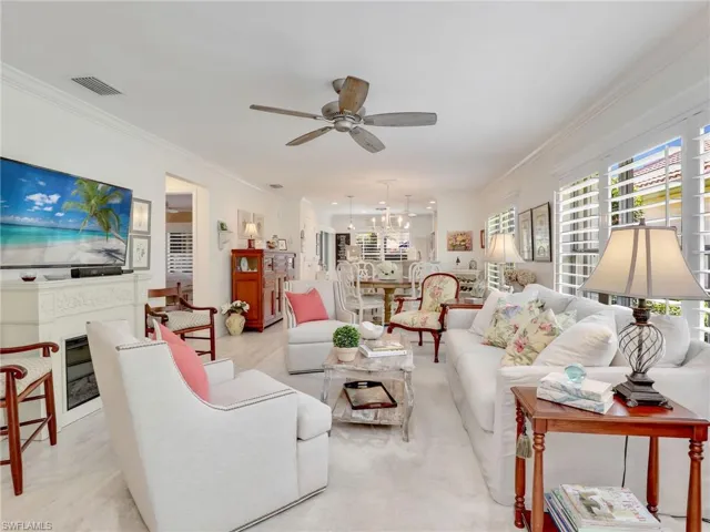 Living room with ornamental molding and ceiling fan