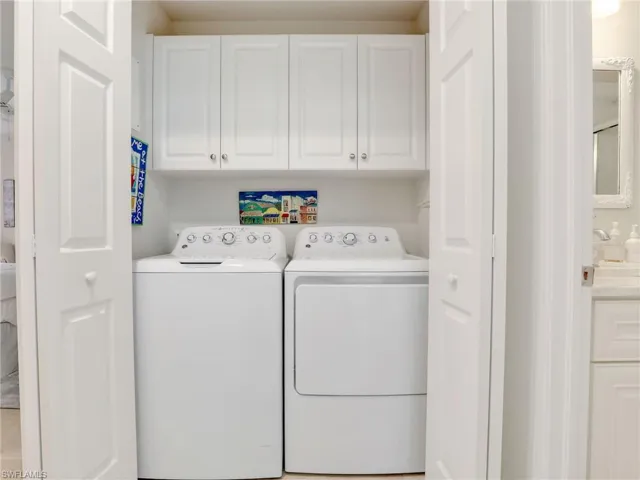Washroom featuring independent washer and dryer and cabinets