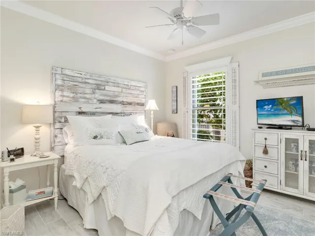 Bedroom with light hardwood / wood-style floors, ornamental molding, and ceiling fan