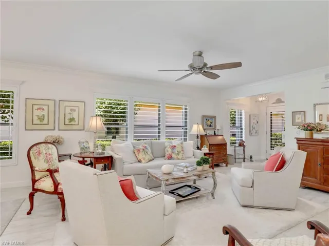 Living room with ceiling fan, a wealth of natural light, and ornamental molding