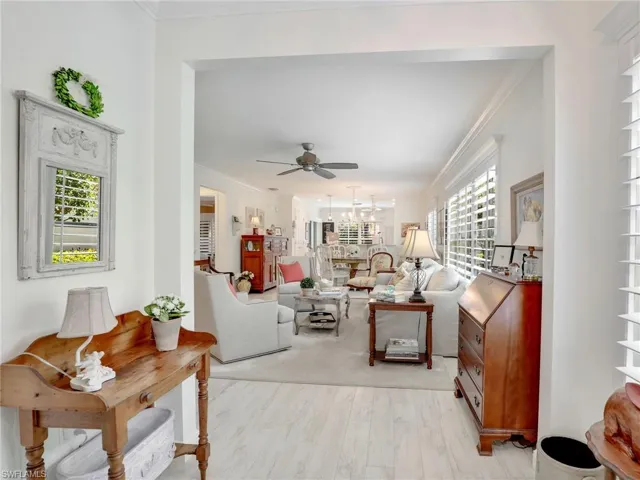 Living room with hardwood / wood-style flooring, ceiling fan, and ornamental molding