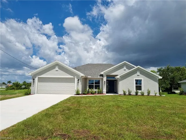 View of front facade with a garage and a front lawn
