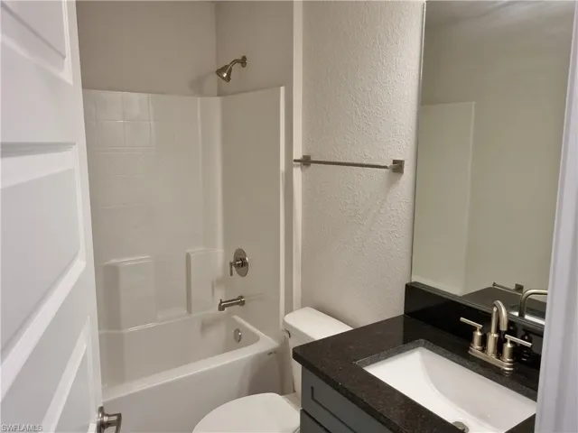 Full bathroom with vanity, shower / washtub combination, and toilet