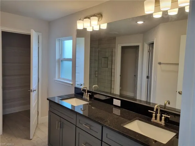 Bathroom featuring tile patterned floors and double sink vanity