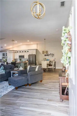 Living room featuring a notable chandelier and vaulted ceiling