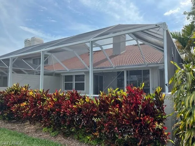 Rear view of house featuring glass enclosure